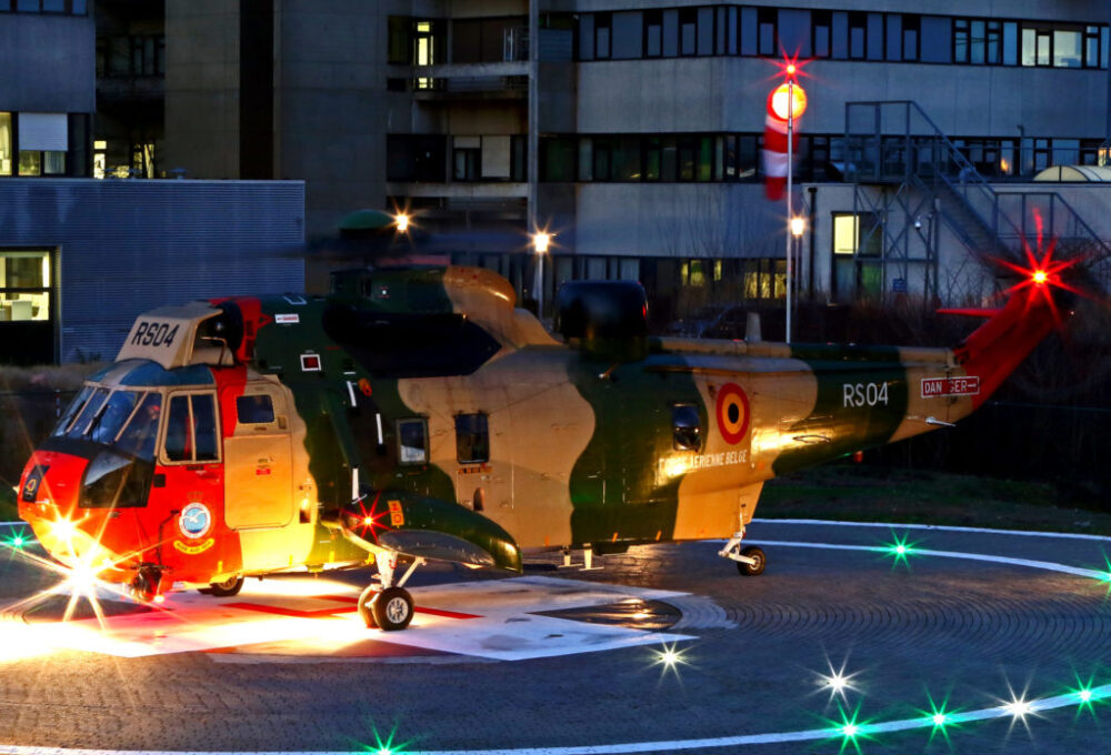 helicopter at dusk with internally lighted windsock assembly in the background next to the hospital.